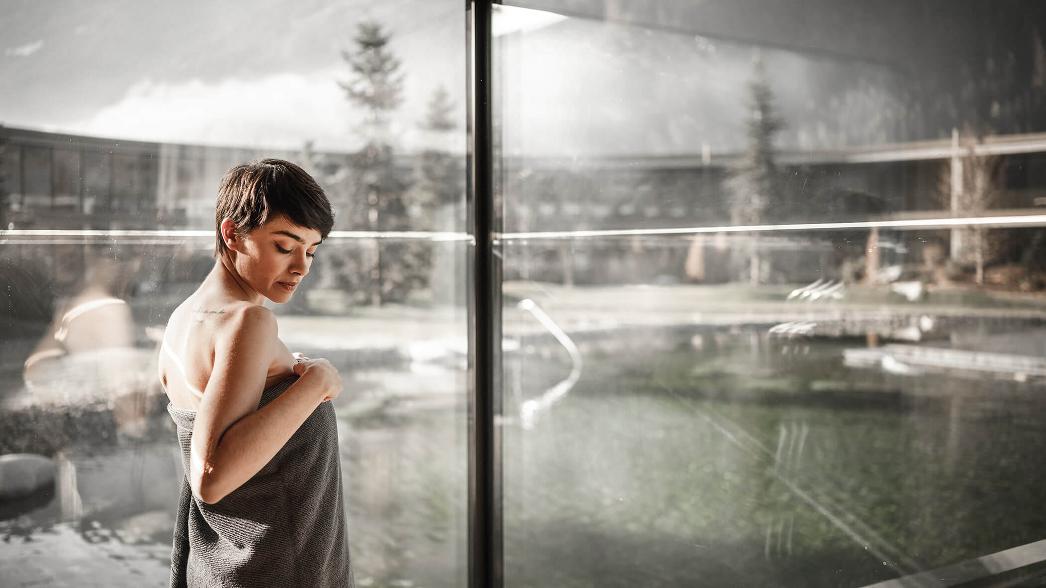 Frau mit Handtuch vor einem Fenster